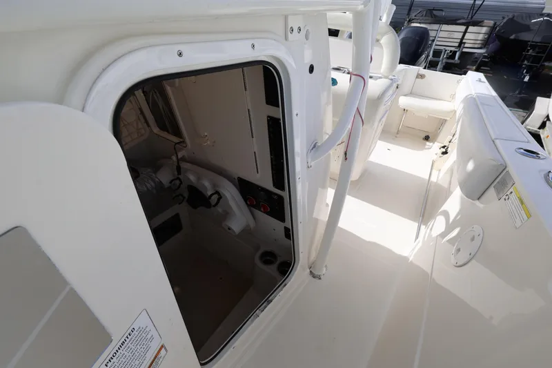 Slide: The Image of 2014 Sailfish 270 CC boat interior with open cabin door, showcasing seating and controls. - 17