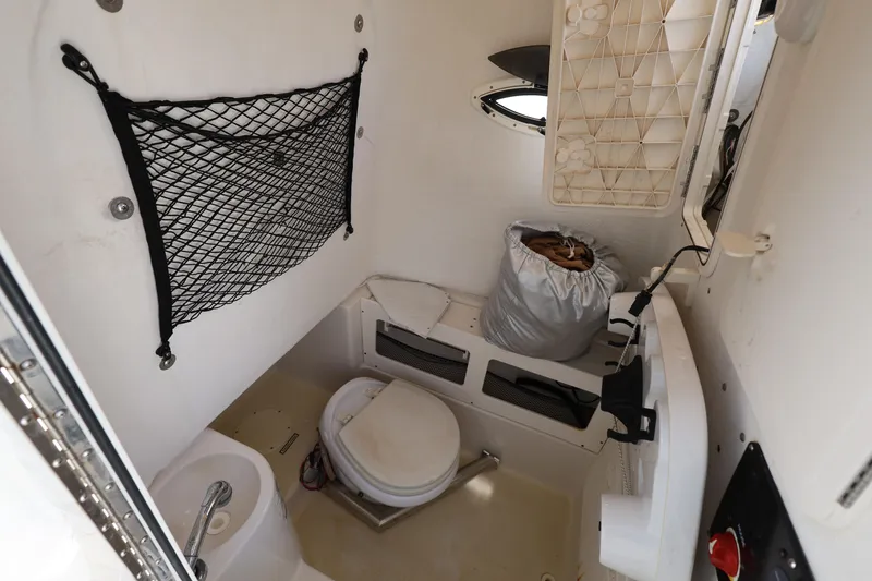 Slide: The Image of 2014 Sailfish 270 CC boat interior with toilet and storage net. - 19