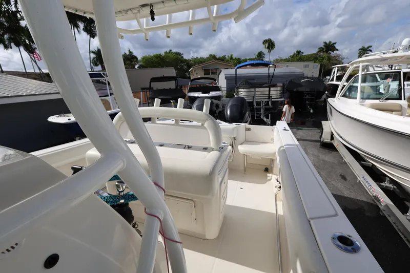 Slide: The Image of 2014 Sailfish 270 CC boat interior with seating, docked among other boats. - 20