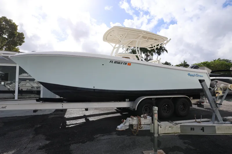 Slide: The Image of 2014 Sailfish 270 CC boat on trailer, side view, under cloudy sky. - 6