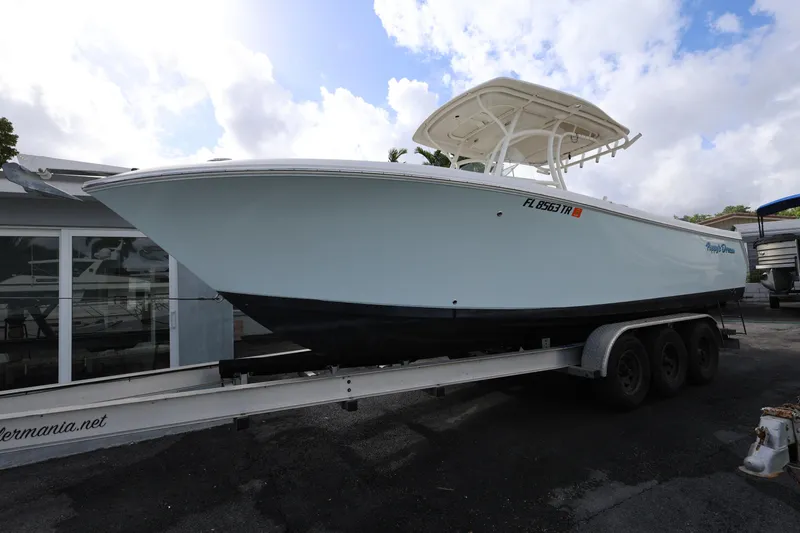 Slide: The Image of 2014 Sailfish 270 CC boat on trailer, parked outdoors under cloudy sky. - 7