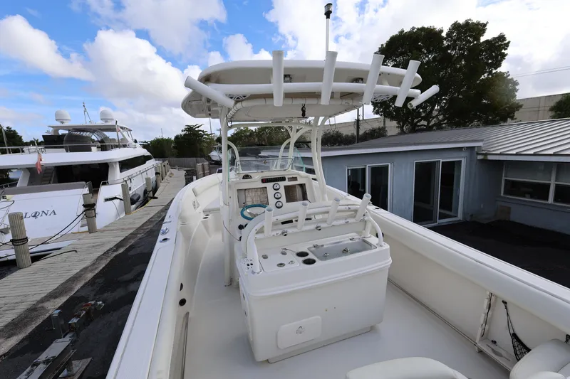 Slide: The Image of 2014 Sailfish 270 CC boat docked, featuring a spacious deck and modern controls. - 8