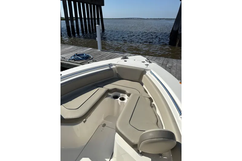 Slide: The Image of 2024 Key West 239 FS boat interior with seating, docked by the water. - 2