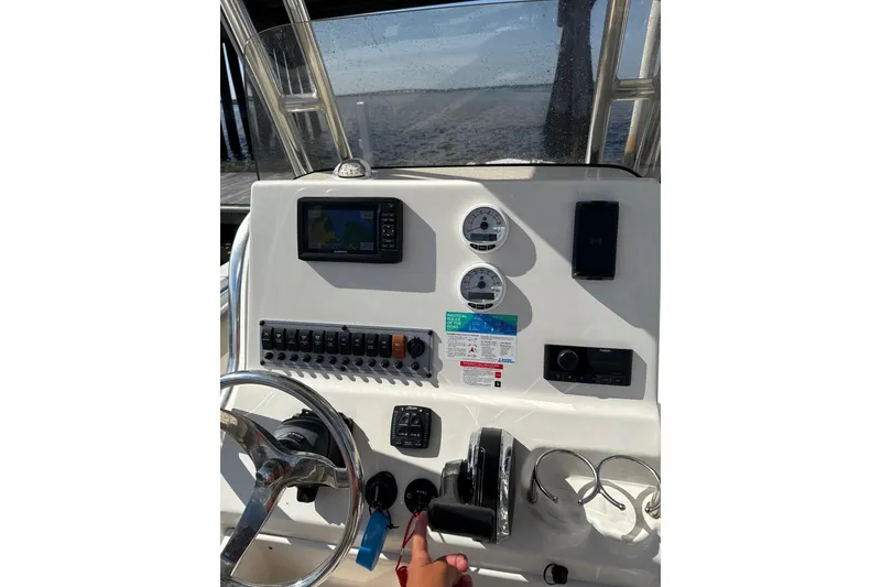 Slide: The Image of 2024 Key West 239 FS boat dashboard with steering wheel, gauges, and navigation system. - 3