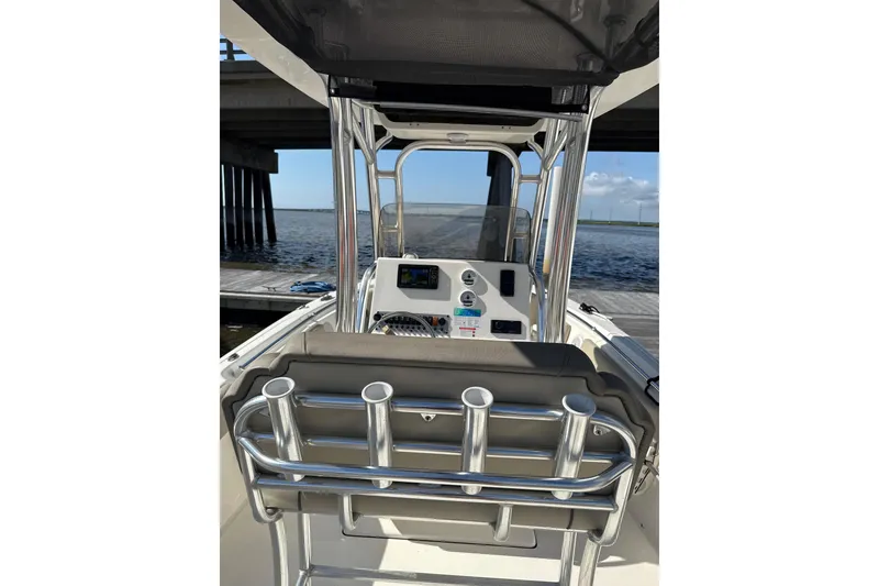 Slide: The Image of 2024 Key West 239 FS boat interior with console and rod holders, docked by water. - 4