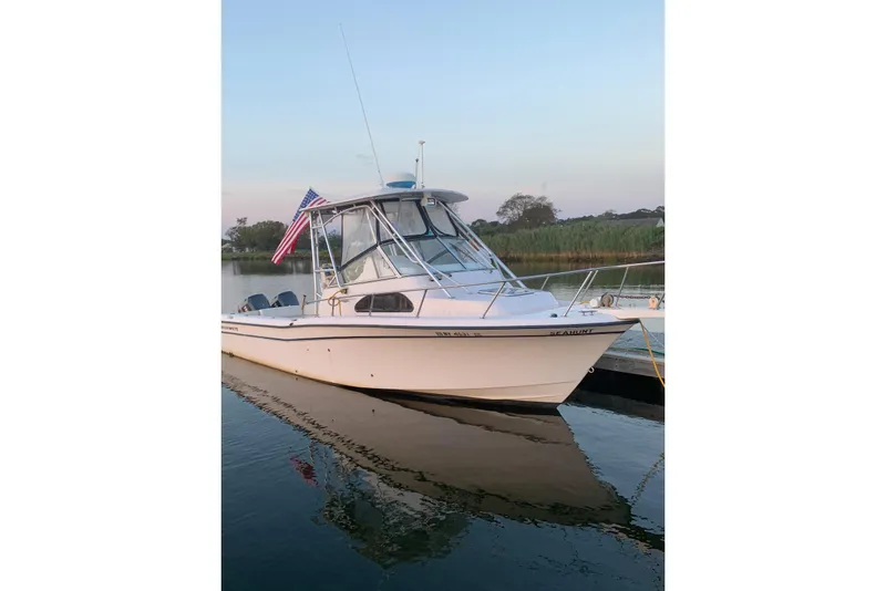The Image of 2001 Grady-White Sailfish 282 boat docked on calm water with American flag. - 0