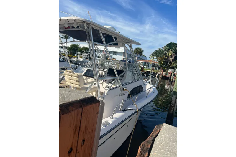 Slide: The Image of 2001 Grady-White Sailfish 282 boat docked, featuring a sturdy frame and clear skies. - 2