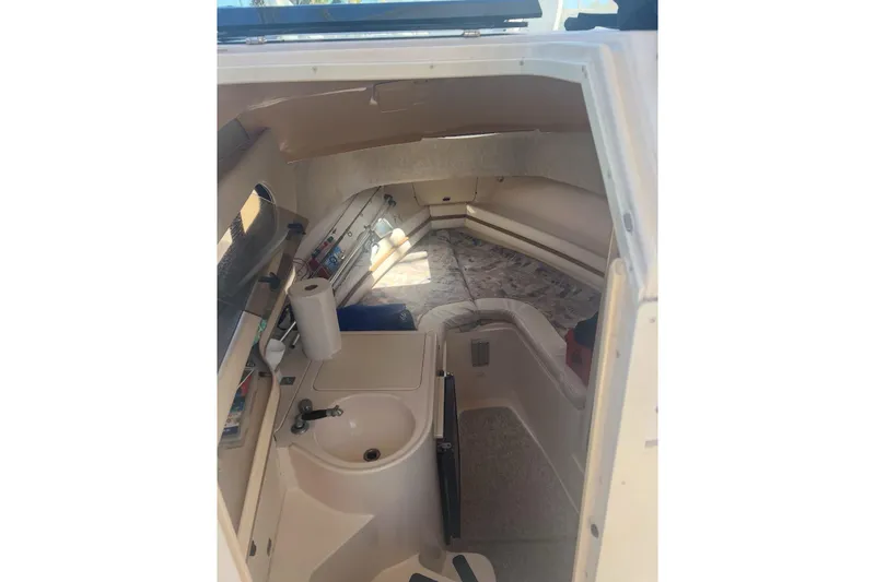 Slide: The Image of Interior cabin of 2001 Grady-White Sailfish 282 boat, featuring a compact sink and seating area. - 5