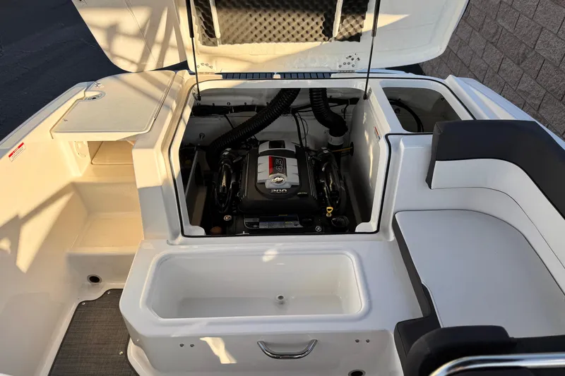 Slide: The Image of 2022 Bayliner VR5 Bowrider I/O engine compartment with open hatch and seating area. - 16