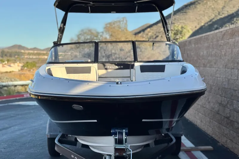 Slide: The Image of 2022 Bayliner VR5 Bowrider I/O boat on trailer, scenic mountain background. - 2