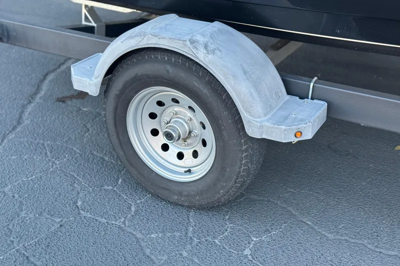 Slide: The Image of Trailer wheel and fender of 2022 Bayliner VR5 Bowrider I/O on asphalt. - 25
