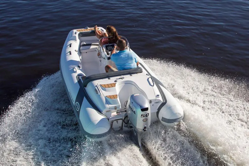 Slide: The Image of Manufacturer Provided Image: 2025 Walker Bay Generation 400 DLX boat cruising on water with two passengers. - 1