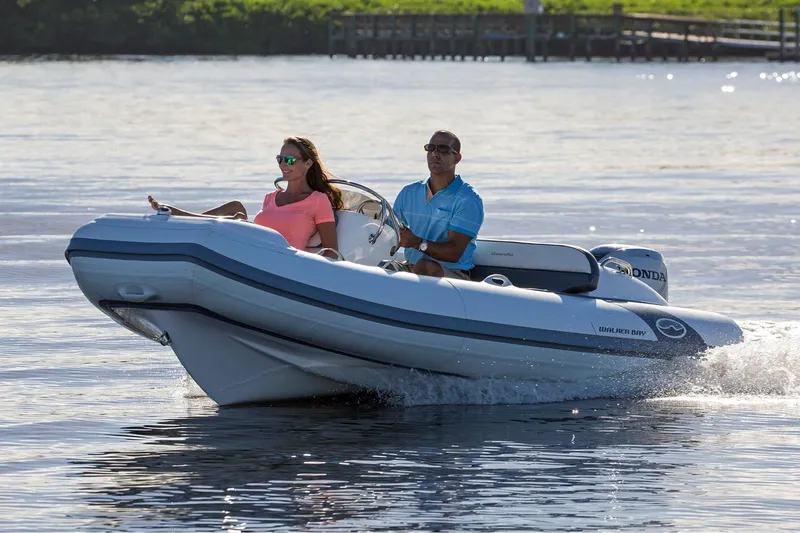 Slide: The Image of Manufacturer Provided Image: 2025 Walker Bay Generation 400 DLX boat cruising on water with two passengers. - 5