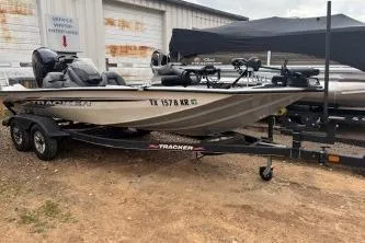 Slide: The Image of 2023 Tracker Pro Team 195 TXW Tournament Edition boat on trailer, parked outdoors. - 2