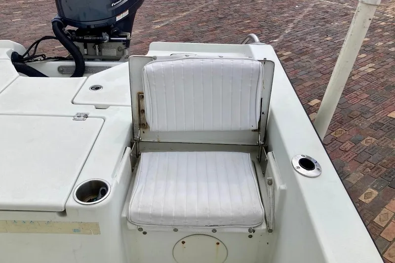 Slide: The Image of White seating area on a 2007 Coastal Bay 2310 boat, featuring a motor and cup holder. - 39