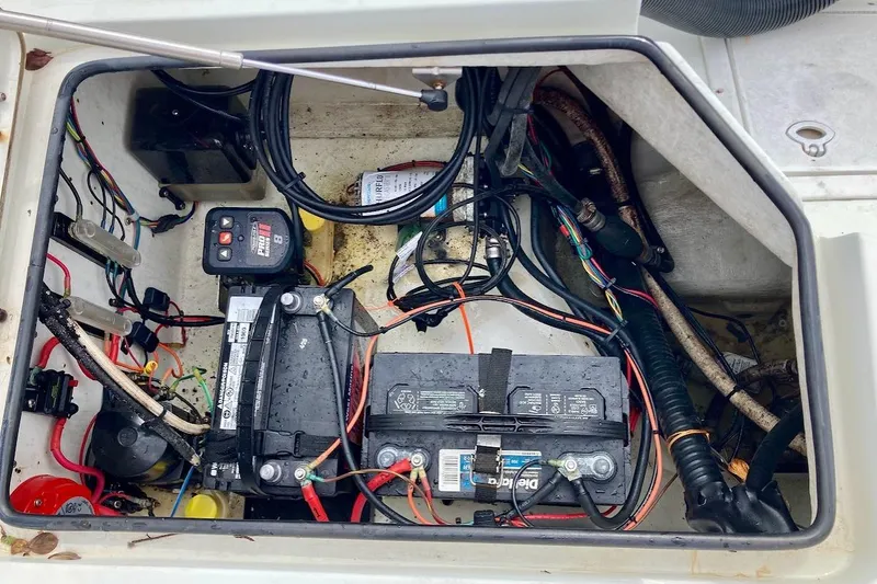 Slide: The Image of Electrical compartment of a 2007 Coastal Bay 2310 boat, featuring batteries and wiring. - 44