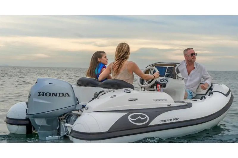 The Image of Manufacturer Provided Image: Walker Bay Generation 12 boat cruising with passengers, featuring a Honda outboard motor, 2025 model. - 1