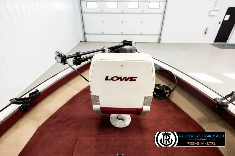 Slide: The Image of 1999 Lowe Sea Nymph V 179 SCX boat interior with maroon carpet and steering console. - 14