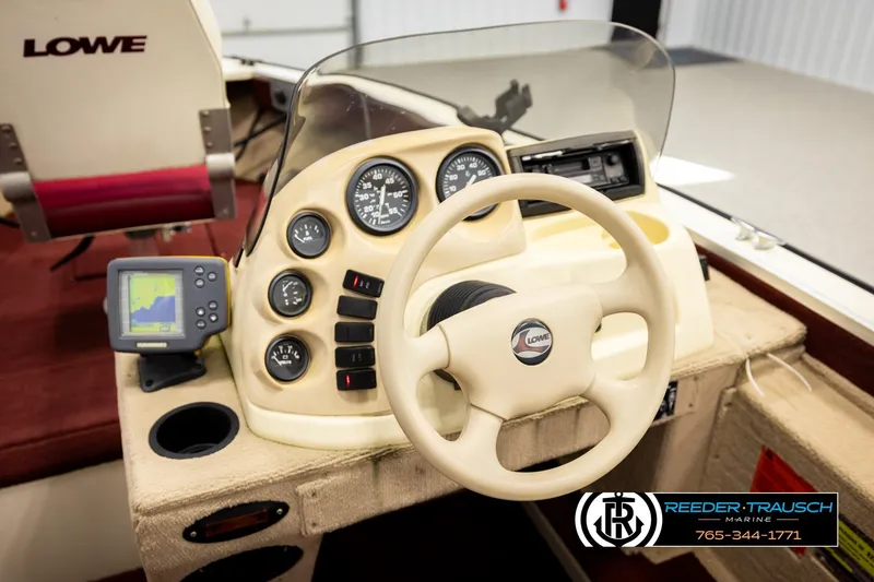 Slide: The Image of 1999 Lowe Sea Nymph V 179 SCX boat dashboard with steering wheel and navigation equipment. - 26