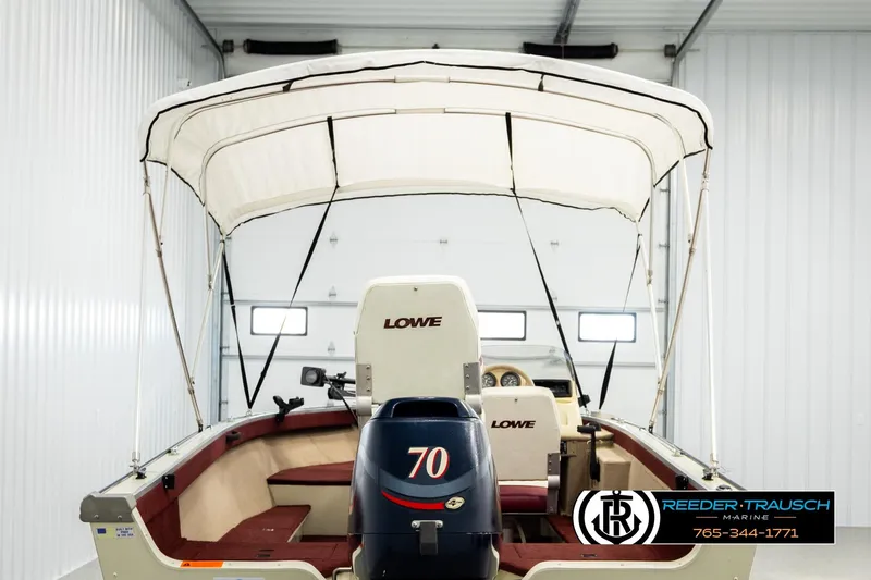 Slide: The Image of 1999 Lowe Sea Nymph V 179 SCX boat with canopy in a garage setting. - 6