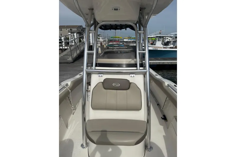 Slide: The Image of 2024 Key West 239 FS boat interior with seating and metal frame, docked at marina. - 5