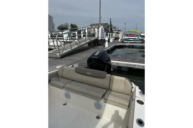 Slide: The Image of 2024 Key West 239 FS boat docked, featuring beige seating and outboard motor. - 6