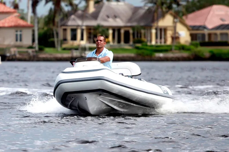Slide: The Image of Manufacturer Provided Image: Man driving 2025 Walker Bay Generation 11 LTE boat on a scenic waterway. - 1