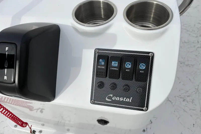 Slide: The Image of Control panel of 2026 Coastal Skiff 271 boat with switches and cup holders. - 15