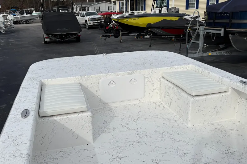 Slide: The Image of 2026 Coastal Skiff 271 boat interior with white cushioned seating and marbled deck design. - 7