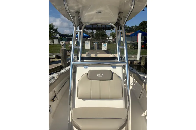 Slide: The Image of 2024 Key West 239 FS boat interior with seating and console, docked outdoors. - 4