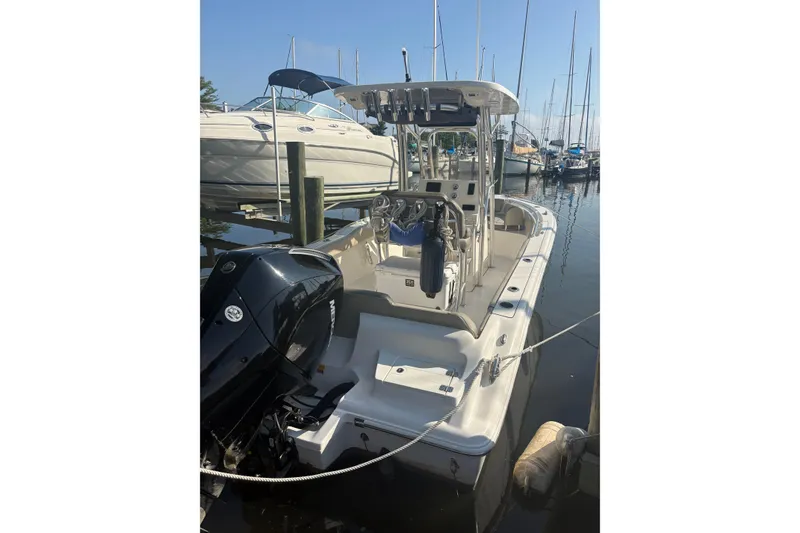 Slide: The Image of 2024 Key West 239 FS boat docked at marina, featuring outboard motor and sleek design. - 6