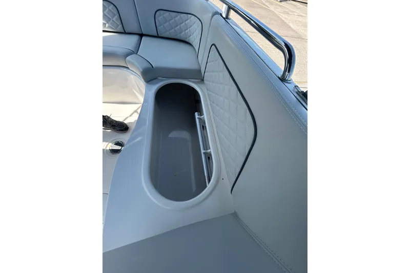 Slide: The Image of 2022 Sea Pro Citation 2400 boat interior with cushioned seating and storage compartment. - 16