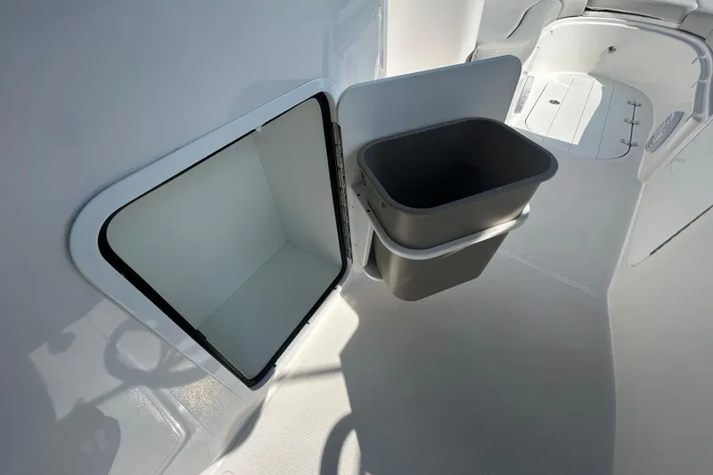 Slide: The Image of 2022 Sea Pro Citation 2400 boat interior with storage compartment and trash bin. - 23