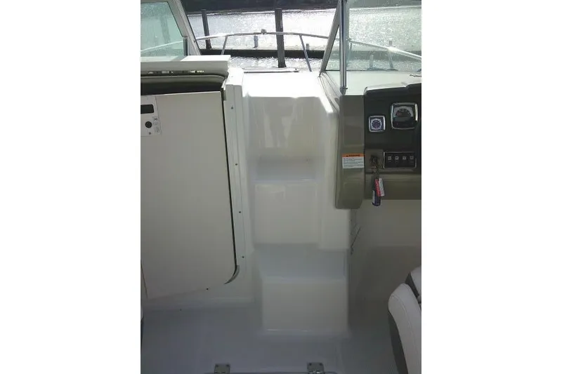 Slide: The Image of 2016 Chaparral 225 SSi boat interior with helm and steps. - 25