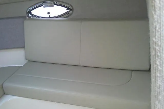 Slide: The Image of 2016 Chaparral 225 SSi boat interior with beige seating and oval window. - 36
