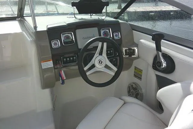 Slide: The Image of 2016 Chaparral 225 SSi boat cockpit with Garmin navigation system and steering wheel. - 49