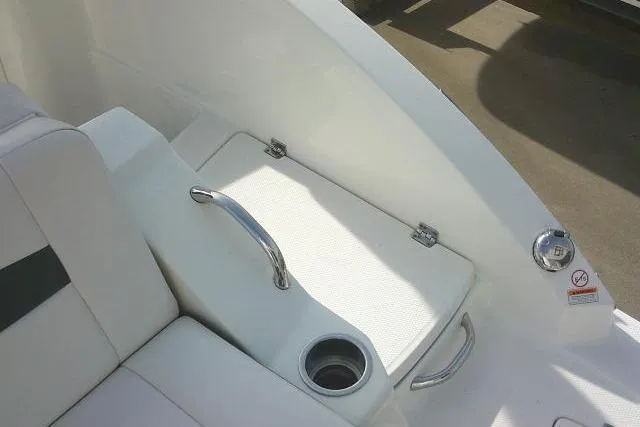Slide: The Image of 2016 Chaparral 225 SSi boat interior with seating, cup holder, and storage compartment. - 52