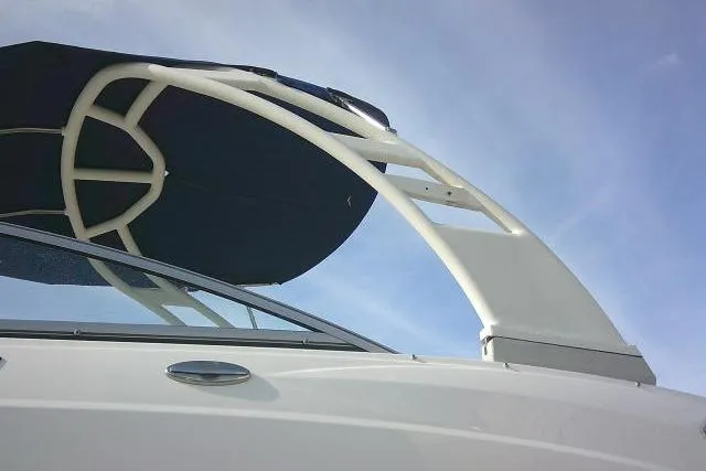 Slide: The Image of 2016 Chaparral 225 SSi boat with sleek design and canopy against blue sky. - 6