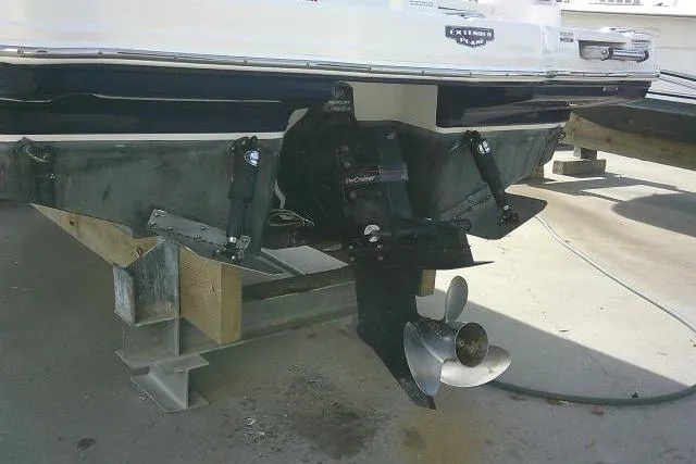 Slide: The Image of 2016 Chaparral 225 SSi boat stern with propeller and outdrive on a stand. - 8