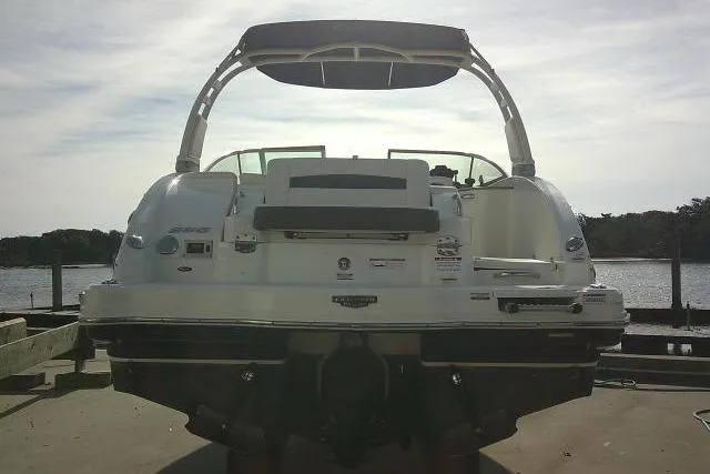 Slide: The Image of 2016 Chaparral 225 SSi boat docked, rear view with canopy, on a sunny day. - 9