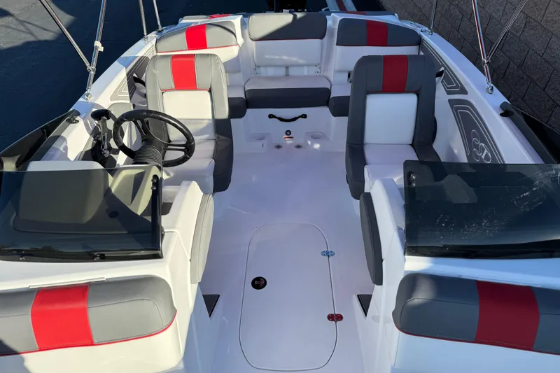 Slide: The Image of 2024 Tahoe T21 boat interior with red and gray seating, steering wheel, and windshield. - 12