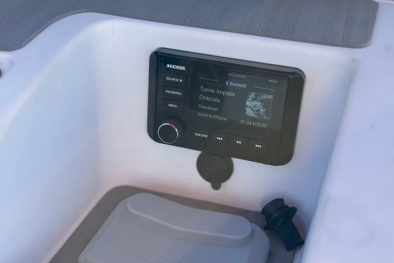 Slide: The Image of 2024 Tahoe T21 boat audio system displaying music track on Kicker media center. - 18