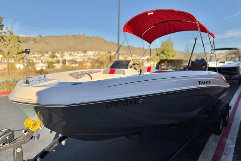 Slide: The Image of 2024 Tahoe T21 boat with red canopy on trailer, scenic background. - 3