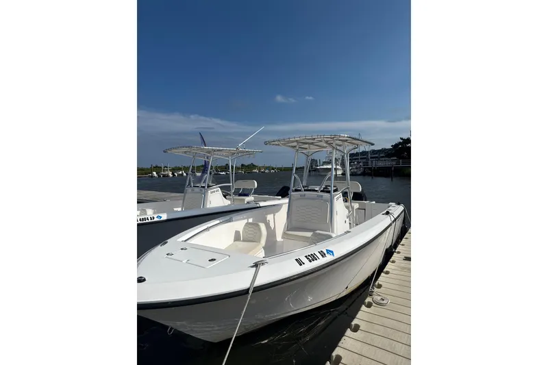 The Image of 2024 Aquasport 2200 Center Console boat docked under clear blue sky. - 0
