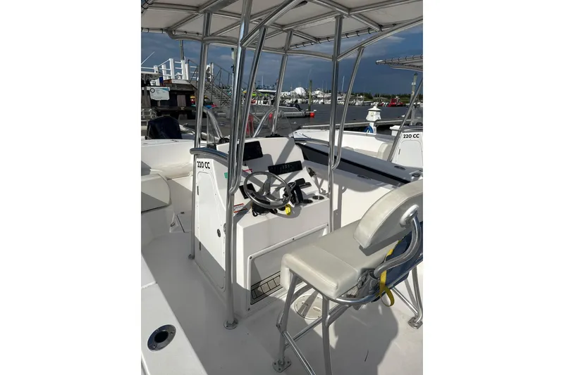 Slide: The Image of 2024 Aquasport 2200 Center Console boat interior with steering wheel and seating. - 4