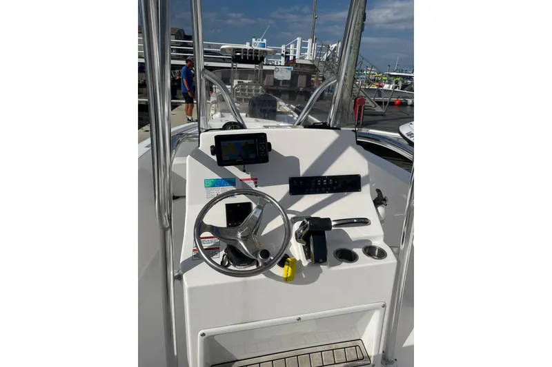 Slide: The Image of 2024 Aquasport 2200 Center Console boat dashboard with steering wheel and navigation equipment. - 5