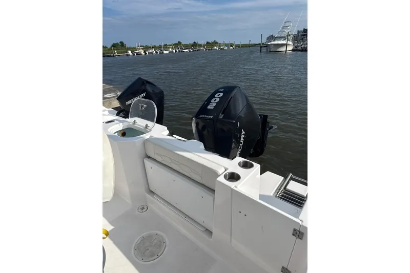 Slide: The Image of 2024 Aquasport 2200 Center Console boat with dual Mercury engines docked by the water. - 8