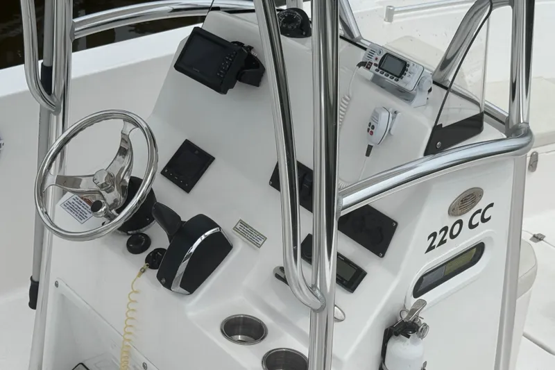 Slide: The Image of 2024 Aquasport 2200 Center Console boat dashboard with steering wheel and navigation equipment. - 5