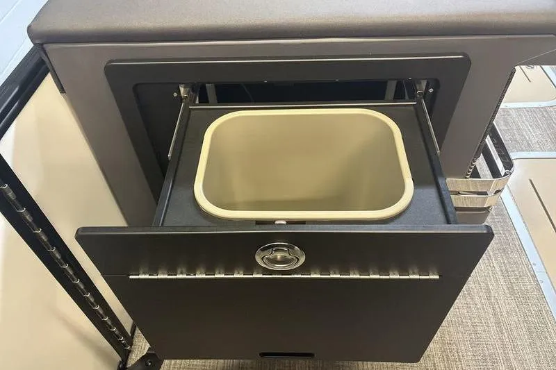 Slide: The Image of 2026 Bennington 24 MSL boat storage compartment with open drawer and bin. - 15