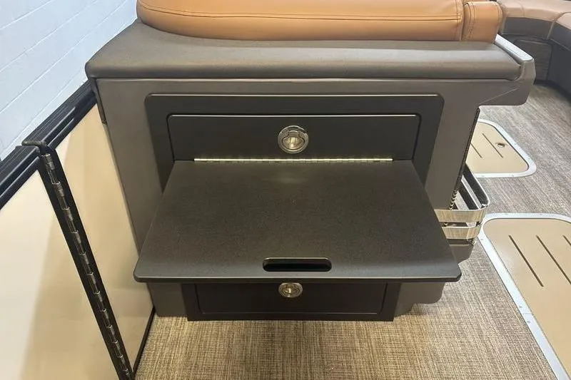 Slide: The Image of 2026 Bennington 24 MSL boat interior with storage compartment and pull-out tray. - 16